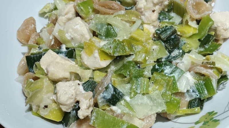 assiette avec des poireaux, des pâtes et du poulet