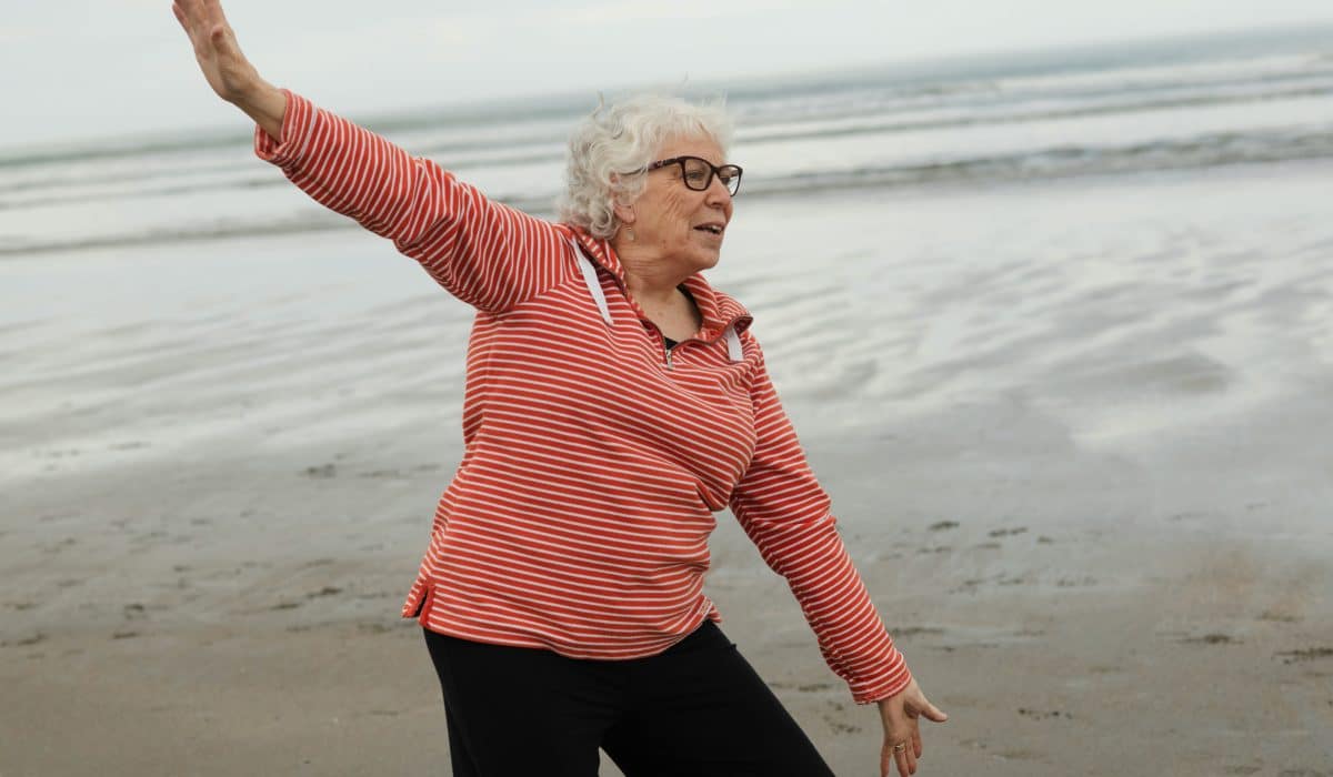 femme âgée faisant de la gym sur la plage