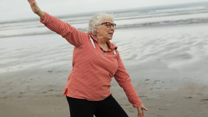 femme âgée faisant de la gym sur la plage